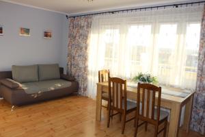 a living room with a couch and a table and chairs at Apartament 2-pokojowy in Ustka