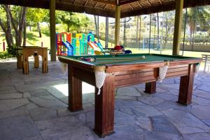 a pool table in front of a playground at Flat térreo 2 quartos no Marulhos Resort - Beira mar Muro Alto in Porto De Galinhas