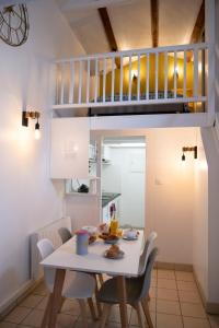 uma pequena cozinha e sala de jantar com mesa e cadeiras em Le Duplex à Mimine em Le Pin-en-Mauges