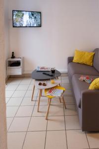 uma sala de estar com um sofá e uma mesa em Le Duplex à Mimine em Le Pin-en-Mauges
