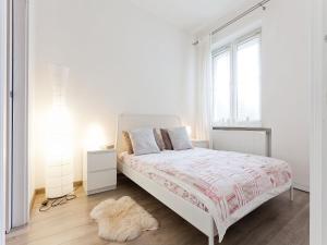 ein weißes Schlafzimmer mit einem Bett und einem Fenster in der Unterkunft Snow White Apartment in Krakau