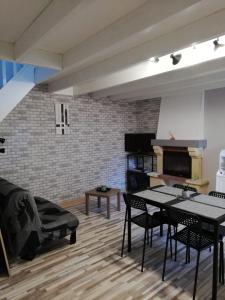 Au Petit Bezion في Sarceaux: غرفة معيشة مع طاولة وكراسي وجدار من الطوب