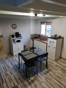 uma pequena cozinha com uma mesa e um fogão em Au Petit Bezion em Sarceaux