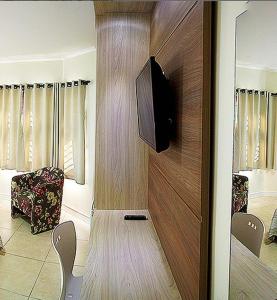 sala de estar con TV en una pared de madera en Senior Parque Hotel, en Santa Rosa