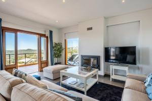 a living room with a couch and a tv at Sunny House in Loulé