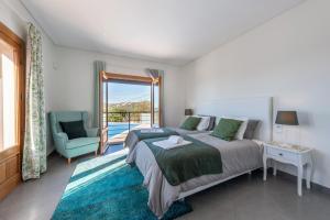a bedroom with a bed and a chair and a window at Sunny House in Loulé +38 photos