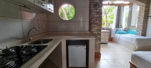 a kitchen with a sink and a stove top oven at Pousada Bodega da Terra in Pirangi do Norte