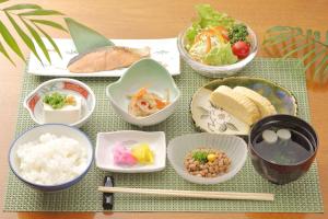 a table topped with bowls of food on a table at Hotel Station Kyoto West in Kyoto