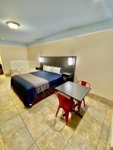 a bedroom with a bed and a table and a desk at Texas Inn & Suites McAllen at La Plaza Mall and Airport in McAllen