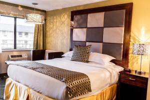 - une chambre avec un grand lit et une grande tête de lit dans l'établissement Gateway Inn and Suites, à Salida