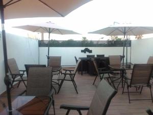 een eetkamer met tafels, stoelen en parasols bij Hotel MAC7 in Aguascalientes