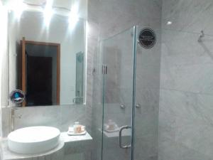 y baño con ducha, aseo y lavamanos. en Hotel MAC7, en Aguascalientes