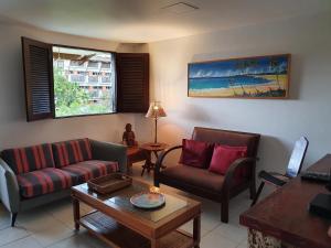 un soggiorno con divano, sedie e tavolo di Condomínio Merepe Residence Duplex a Porto De Galinhas