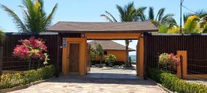una entrada de madera a una casa con una valla en Guille Bungalows, en Canoas de Punta Sal