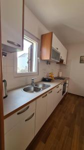 una pequeña cocina con fregadero y ventana en Apartment Antonia en Stari Grad