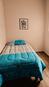 a bed with a blue comforter in a bedroom at Cabañas Alto Volcanes in Puerto Montt