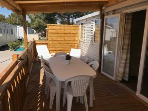un tavolo bianco e sedie su una terrazza di Mobil Home camping Mar Estang bord de plage a Canet-en-Roussillon