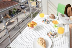 a table with plates of bread and fruit on it at Aveiro Photo House - Bairro calmo no centro de Aveiro in Aveiro
