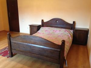 Cama de madera en un dormitorio con suelo de madera en Formula Plus Motel, en Lutsk