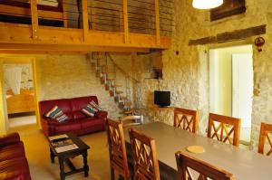 a living room with a table and a red couch at Gîtes du Domaine des Dames in Vallon-Pont-dʼArc