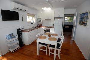 uma cozinha com uma mesa e cadeiras e um frigorífico em Sea-Esta @ Inverloch em Inverloch