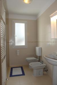 リニャーノ・サッビアドーロにあるVilla Brunaのバスルーム(トイレ、洗面台付)、窓が備わります。