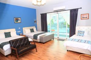 a bedroom with two beds and a chair and a window at 500Km Home in Hualien City