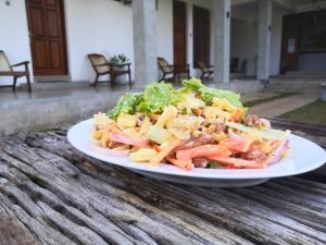 a plate with a salad on a table at Kudila Resort in Anuradhapura