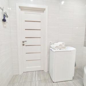 a white bathroom with a toilet and a door at квартира в Жилом комплексе Левитана,массив Радужный in Odesa +28 photos