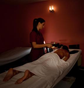 a woman standing next to a man in a bed at Virgilio Grand Hotel in Sperlonga