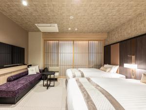 京都市にあるホテルミュッセ京都四条河原町名鉄のベッド2台とソファが備わるホテルルームです。