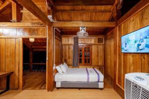1 dormitorio con 1 cama y TV de pantalla plana en Suncosy Central Resort, en Phu Quoc