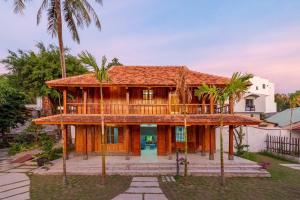 Casa de madera con balcón y palmeras en Suncosy Central Resort, en Phu Quoc