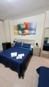 um quarto com uma cama azul com duas almofadas em Hostal Doña María em Valdemoro