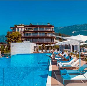 a swimming pool with lounge chairs and a hotel at Sea View Villas in Duklei in Budva