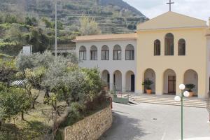 uma igreja com uma cruz no lado de uma colina em Ancelle Sorrento - Casa d'Accoglienza em Castellammare di Stabia