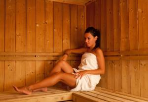 a woman is sitting in a sauna at Virgilio Grand Hotel in Sperlonga