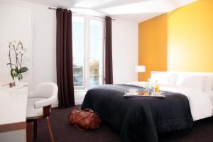 a hotel room with a bed with a tray of food on it at Logis Hôtel La Ruche in Rolleboise