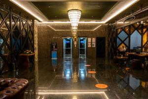 een lobby van een hotel met een bank en een kroonluchter bij Avec Hotel in Canakkale