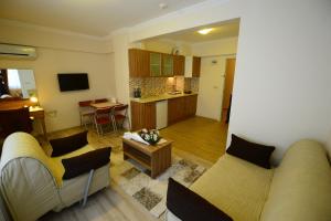 een woonkamer met twee banken en een keuken bij Dort Mevsim Suit Hotel in Canakkale