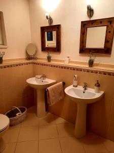 a bathroom with two sinks and a mirror and a toilet at Chalupa Levandula in Šumiac