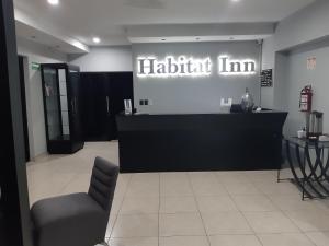 a waiting room with a black counter and a chair at Habitat Inn in Tapachula