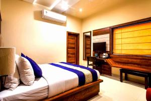 a bedroom with a bed and a desk with a computer at Hotel Spiti in Mathura