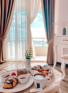 a breakfast tray with pastries and coffee cups on a table at Hotel Majestic in Durrës