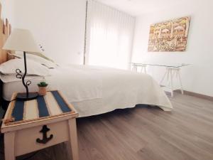 a bedroom with a bed and a table with a lamp at Casa Martí in El Vendrell +40 photos