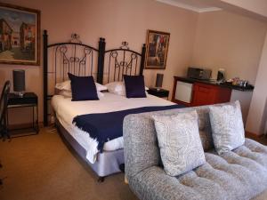 1 dormitorio con 1 cama grande y 1 sofá en Casa Mia Health Spa and Guesthouse, en Addo