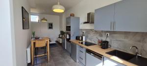 a kitchen with white cabinets and a counter top at Chez Charles Centre-Parking privé-Hospices-Gare in Beaune
