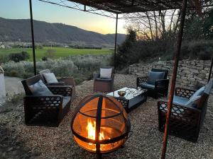 a fire pit in a yard with chairs and a table at Gîte La maison dans l'Olivette in Oraison