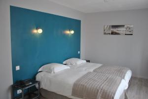 1 dormitorio con 1 cama grande y pared azul en Logis Hermitage en Perros-Guirec