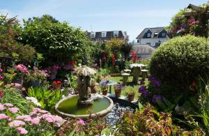 un jardín con una fuente en medio de flores en Poltair Guest House en Falmouth